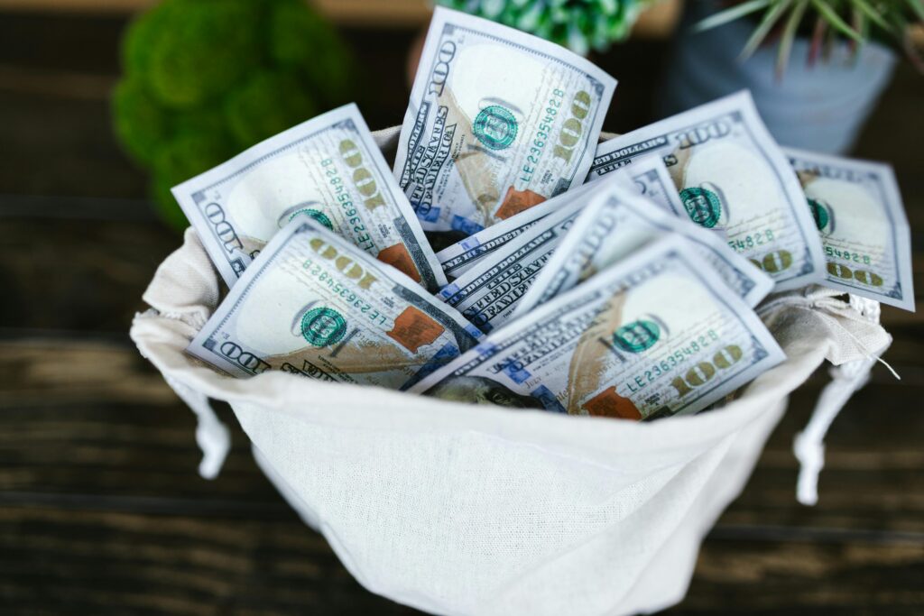 A top view of a sack brimming with US 100 dollar bills, symbolizing wealth and prosperity.